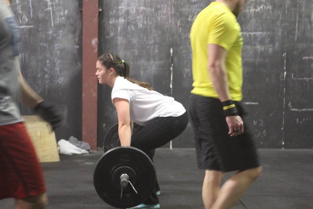 Kelly K. showing how to maintain a straight back as she lowers a power snatch mid metcon!